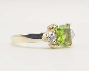 Elegant vintage ring made of 585 gold with a glowing tsavorite and sparkling white zircons
