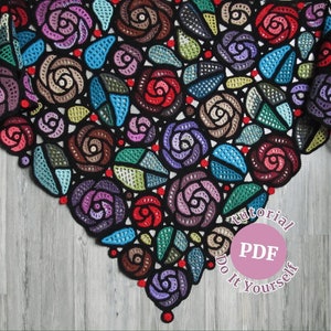 May include: A black crochet shawl with a design of colorful roses. The shawl is on a wooden surface. The text "Tutorial PDF Do It Yourself" is on a pink circle.