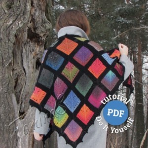 May include: A colorful crocheted shawl with black squares and a diamond pattern. The shawl is worn by a person standing in a snowy forest. The text "tutorial PDF Do It Yourself" is visible in the lower right corner of the image.