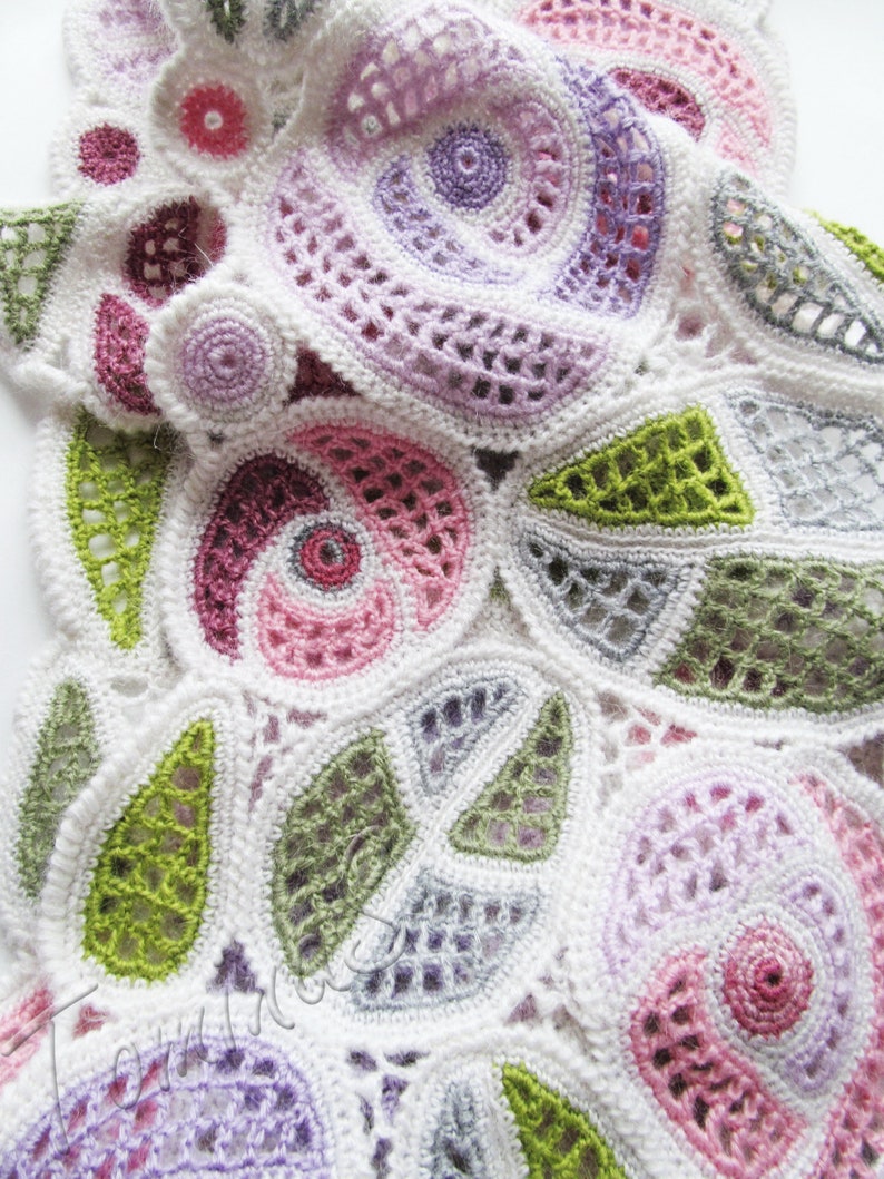 May include: A white crocheted doily with a circular design featuring various colors, including pink, purple, green, and gray.
