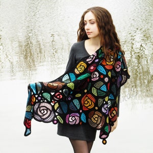 May include: A black crochet shawl with a colorful floral design. The shawl features a variety of colors, including red, orange, yellow, green, blue, and purple. The shawl is made with a delicate crochet stitch and has a fringed edge.