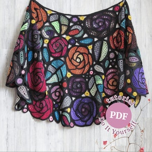 May include: A colorful crochet shawl with a floral design. The shawl is made with a variety of colors, including red, orange, yellow, green, blue, purple, and black. The shawl is crocheted in a delicate pattern that creates a beautiful and intricate design. The shawl is perfect for adding a touch of elegance to any outfit. The text on the image reads "tutorial PDF Do It Yourself".