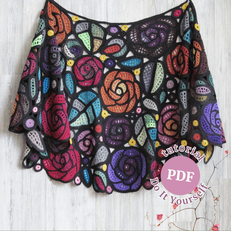 May include: A colorful crochet shawl with a floral design. The shawl is made with a variety of colors, including red, orange, yellow, green, blue, purple, and black. The shawl is crocheted in a delicate pattern that creates a beautiful and intricate design. The shawl is perfect for adding a touch of elegance to any outfit. The text on the image reads "tutorial PDF Do It Yourself".