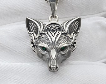 May include: Silver fox head pendant necklace with green gemstone eyes. The pendant is detailed with intricate carvings and a chain.