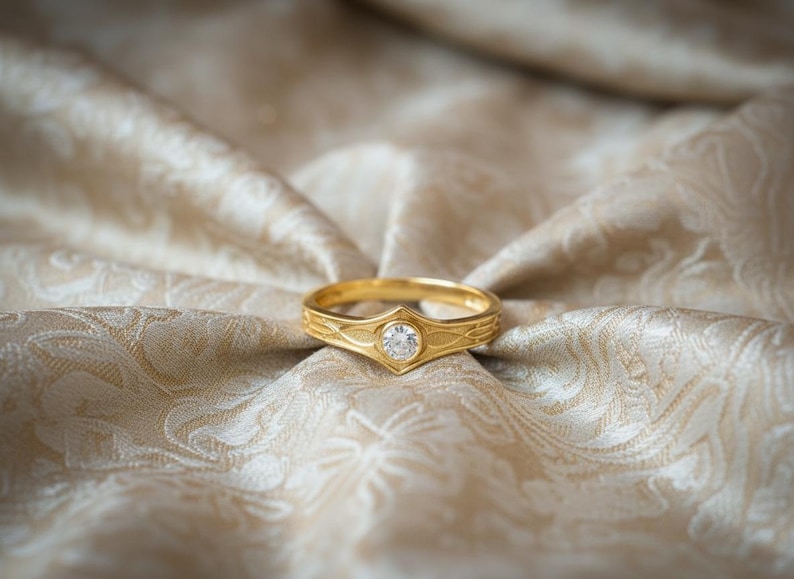 The design is cast in 14k Yellow Gold with a deep red Garnet center. The transformation shifts the aesthetic from "Silver Ranger" to "Royal Guard." The gold amplifies the warmth of the design, making it look like a piece of ancient ceremonial jewelry. The red stone adds a touch of danger and passion, perfect for a romantic, "Power Couple" anniversary gift.