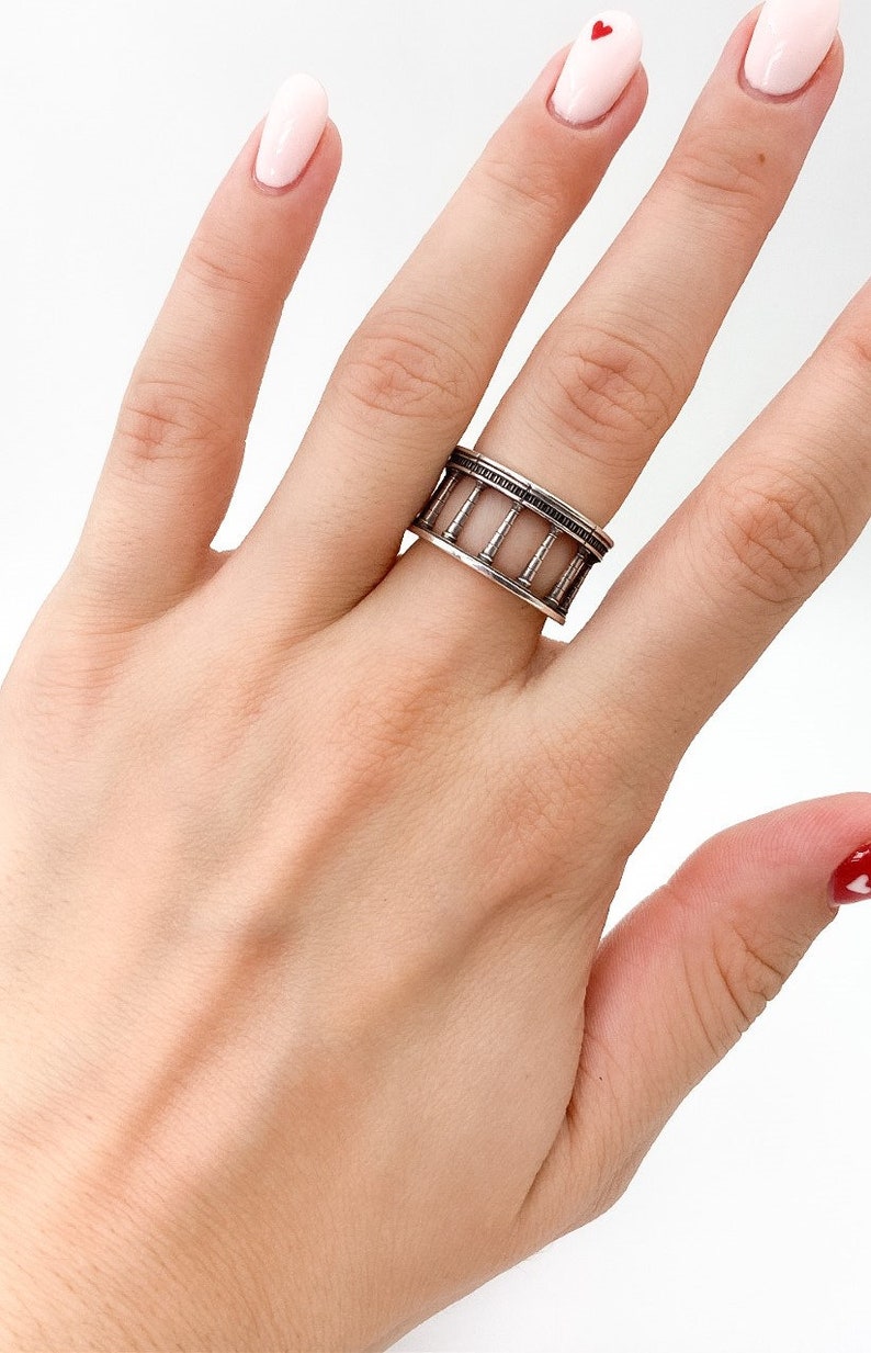 This ring is expertly crafted from high-quality sterling silver, showcasing a sleek and minimalistic design reminiscent of the majestic columns found in classical architecture.