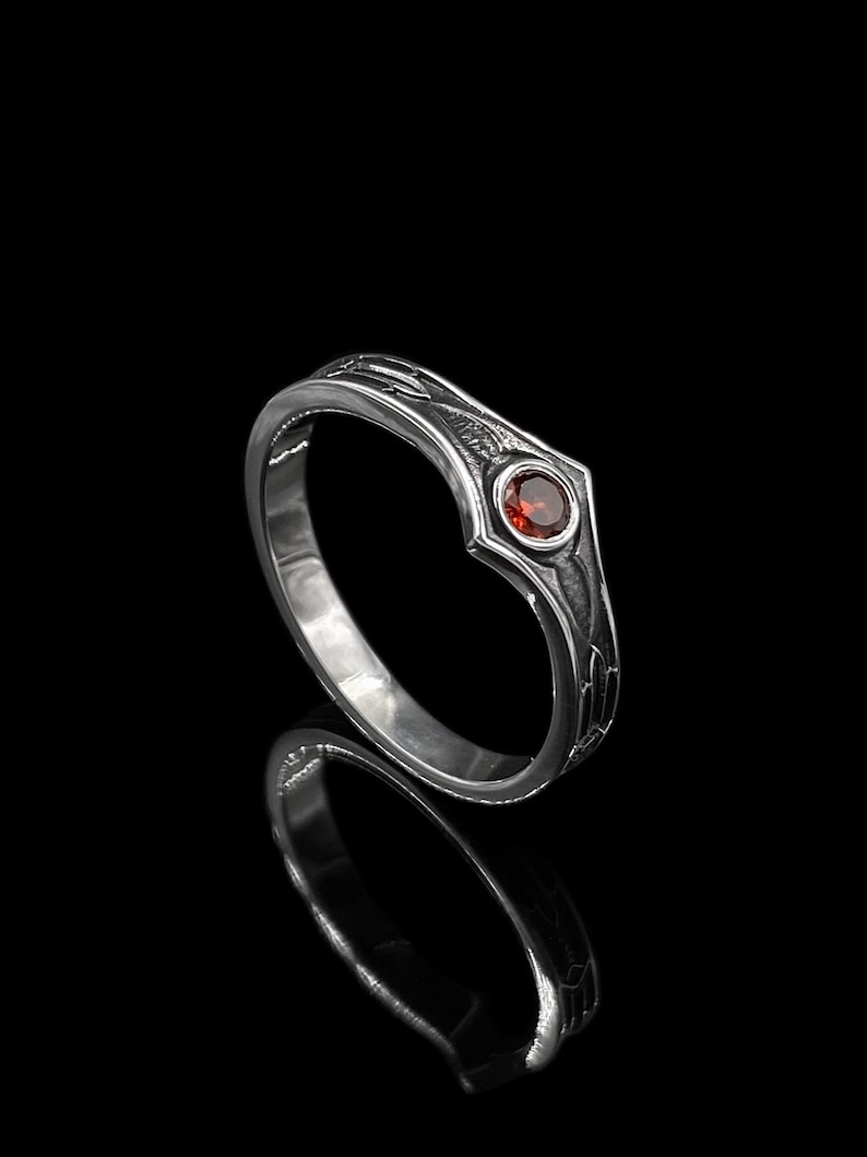 Feel the power of bold self-expression with this sterling silver garnet ring, featuring intricate gothic etching and a fiery red center stone. Handcrafted for the modern alchemist, rebel, or romantic, this piece merges strength with symbolism — the deep red garnet evokes passion, protection, and purpose.