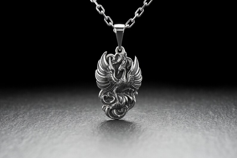Introducing our stunning Silver Phoenix Pendant! Handcrafted with the finest quality sterling silver, this piece is sure to impress. The intricate design showcases a beautifully detailed phoenix, symbolizing strength, renewal, and rebirth.