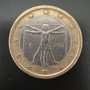Peut inclure: Une pièce de 1 euro de couleur dorée avec un centre argenté représentant l'Homme de Vitruve, un célèbre dessin de Léonard de Vinci. La pièce porte également l'année 2002 et la lettre "R" deux fois.