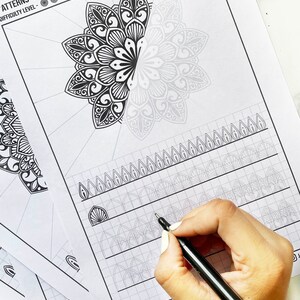 May include: White paper sheets with mandala patterns and the text "Patterns With Mandala" and "Difficulty Level". A hand is holding a black pen, practicing the mandala designs. The Designs By Jayshree logo is visible.