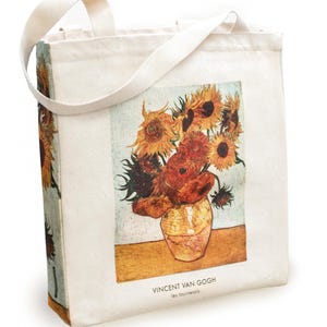 Könnte beinhalten: Eine weiße Canvas-Tragetasche mit einem gedruckten Bild von Vincent van Goghs Gemälde "Sonnenblumen". Die Tasche hat einen braunen Ledergriff und der Text "VINCENT VAN GOGH les tournesols" ist unten aufgedruckt.
