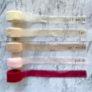 Pu&ograve; includere: Cinque rocchetti di nastro con bordi sfilacciati nei colori off white, tan, light mocha, pinkish e ruby red. Ogni rocchetto &egrave; etichettato con il nome del colore in testo nero. I nastri presentano un aspetto morbido e testurizzato con bordi grezzi.