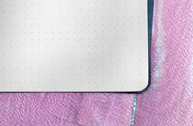 A close-up of a white notebook with a black cover and a dotted grid pattern on the pages. Dot Grid Journal, Dot Grid Journal, Travel Journal, Reading Journal, Journals and Notebooks, Junk Journal, Dot Grid Notebook, Halloween Gift