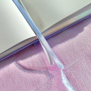 A purple notebook with a white ribbon bookmark. The notebook is open and the pages are blank with small dots. Dot Grid Journal, Dot Grid Journal, Travel Journal, Reading Journal, Journals and Notebooks, Junk Journal, Dot Grid Notebook, Halloween Gift