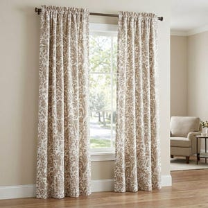May include: Two floor-length window curtains featuring a tan and white damask pattern. The curtains are hung on a dark brown metal rod with decorative finials at each end. The fabric has a gathered top header and hangs in vertical folds.