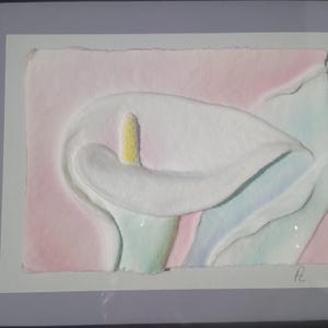 May include: A textured paper art piece featuring a white calla lily with a yellow spadix, set against a soft pink background with subtle blue and green watercolor washes. The artwork is signed with the initials Pc in the bottom right corner.