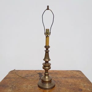 May include: A white ceramic mug with a black handle and the text "But First, Coffee" in a black, bold font. The mug is on a white surface. The mug is approximately 4 inches tall.