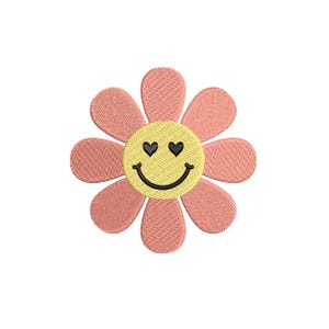 May include: A daisy-shaped design with a yellow centre featuring heart-shaped eyes and a smiling mouth. The petals are a soft peach colour, and the design is set against a white background. Suitable for embroidery or applique.