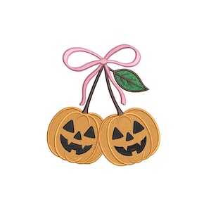 May include: Embroidered design of two orange pumpkins with black carved faces, connected by brown stems and a pink bow. A green leaf is also attached. The design is likely for Halloween or fall-themed crafts.