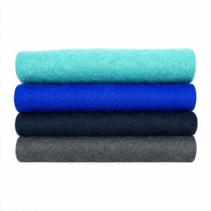 May include: A stack of four rectangular sheets of felt fabric arranged horizontally. The top sheet is turquoise, followed by a vibrant royal blue sheet, a dark navy blue sheet, and a charcoal gray sheet at the bottom. Each layer has a textured surface.