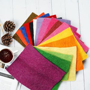 May include: A variety of felt squares in different colors, including purple, green, yellow, orange, red, pink, brown, and blue. The felt squares are arranged in a fan shape.