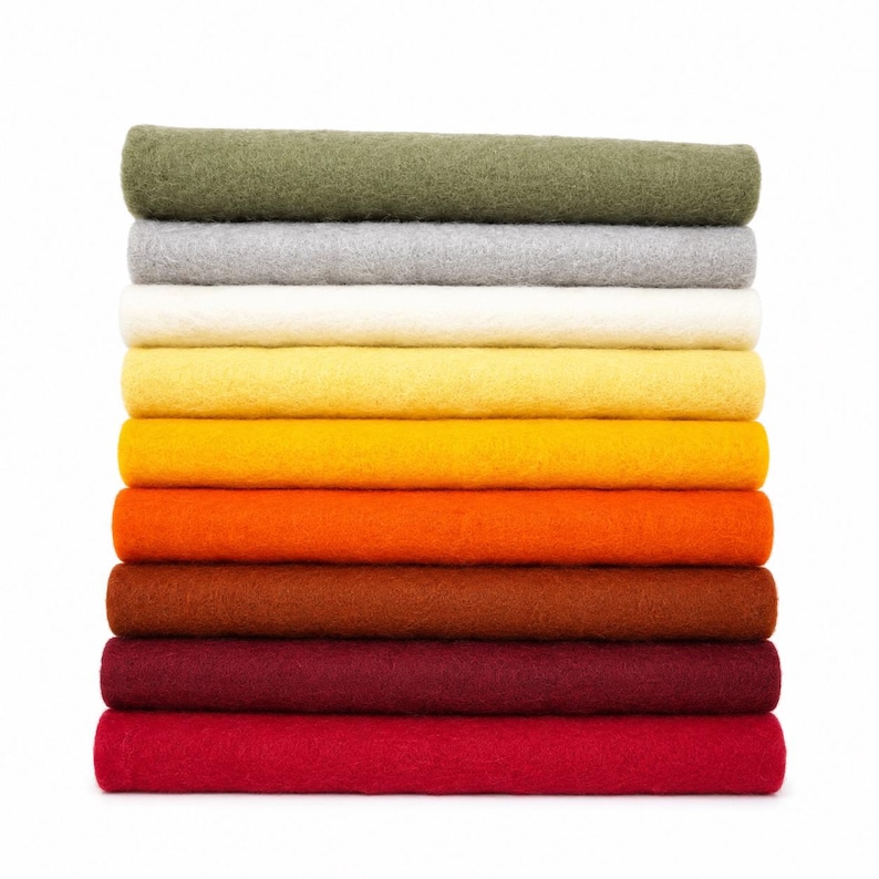 May include: A vertical stack of ten rectangular felt fabric sheets in a gradient of colors, starting from olive green at the top, followed by gray, white, light yellow, golden yellow, orange, brown, dark red, and bright red at the base.