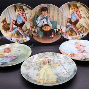 May include: Set of six decorative plates featuring colorful illustrations of children. Each plate depicts a different scene with a child engaged in a playful activity. The plates are circular and have a white background.