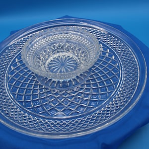 May include: A clear glass serving tray with a smaller bowl in the center. Both pieces have a diamond pattern.