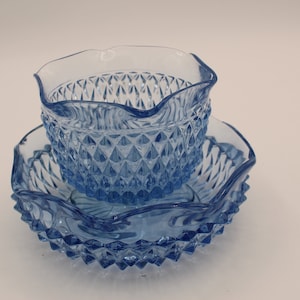 May include: A set of two blue glass bowls with a diamond pattern. The bowls are stacked on top of each other.