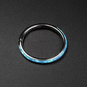 May include: A silver ring with a blue and green opal inlay.