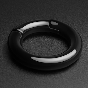 May include: A black, smooth, and shiny ring with a rounded shape. The ring is made of a durable material and has a simple, elegant design.