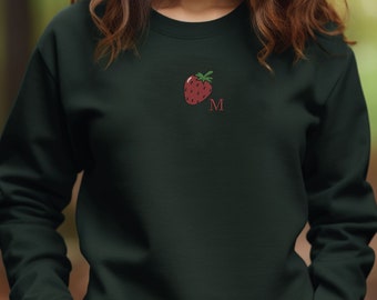 Könnte beinhalten: Ein dunkelgrüner Pullover mit einer roten Erdbeere und dem Buchstaben "M" auf der Vorderseite gestickt. Der Pullover ist anpassbar.