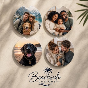 May include: Four circular car coasters featuring custom photo prints. One shows a couple with a golden retriever, another a family with a baby, one a black Labrador on a beach, and the last a couple with a cat. The logo Beachside Customs is below.