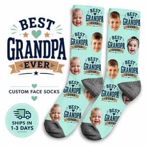 May include: Custom face socks with a light blue background and the words "Best Grandpa Ever" in navy blue. The socks feature multiple photos of children's faces. The text "Custom Face Socks" is also visible.