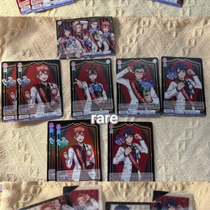 K&ouml;nnte beinhalten: Eine Sammlung von Sammelkarten mit Charakteren im Anime-Stil. Die Karten haben einen roten und schwarzen Rand mit Charakterillustrationen, Text und Zahlen. Einige Karten sind mit "normal", "rare" und "birthday set" beschriftet.