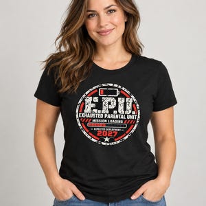 May include: A black short-sleeved t-shirt featuring a circular graphic with red and white text that reads E.P.U. EXHAUSTED PARENTAL UNIT MISSION LOADING EXPECTED DEPLOYMENT 2027, accompanied by a battery icon and a loading bar.