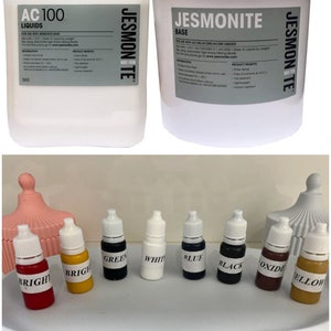 May include: A set of 10 bottles of Jesmonite resin pigments. The bottles are arranged in a row on a white surface. The colors are: bright red, bright yellow, green, white, blue, black, oxide, and yellow.
