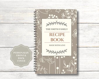 May include: A beige recipe book with a white floral pattern and the text "The Smith Family Recipe Book Made With Love".
