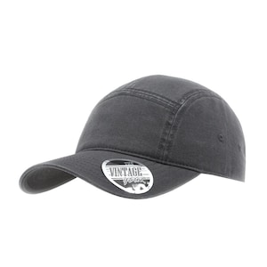 May include: A charcoal gray baseball cap with a curved brim. The cap features a structured crown with a seam detail and a small, circular logo on the front that reads "The Vintage Gear".