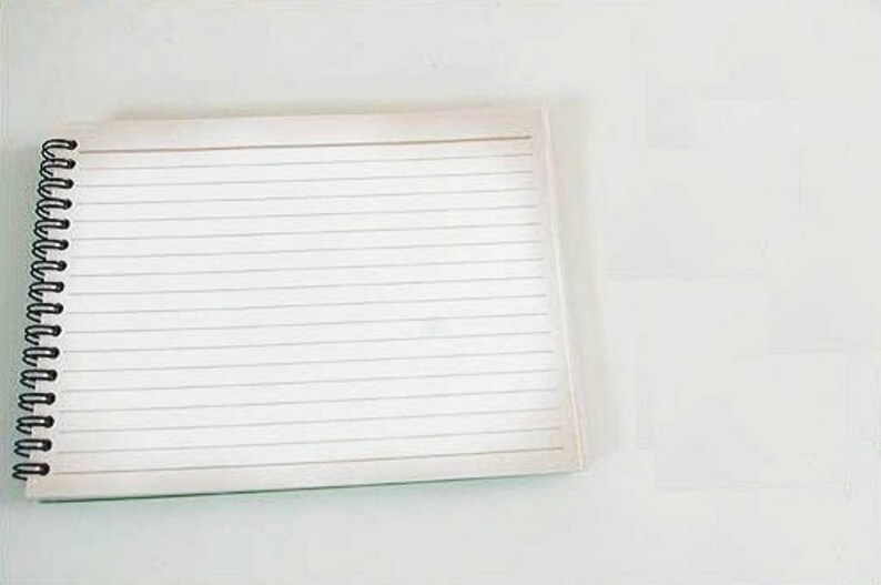 May include: A white spiral bound notebook with lined pages.