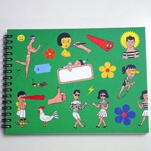 May include: A green spiral bound notebook with colorful illustrations of people, flowers, and geometric shapes. The notebook has a blank white rectangle in the center.