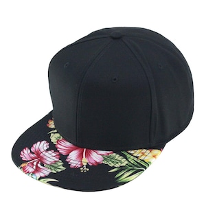 Puede incluir: Una gorra de béisbol negra y blanca con un estampado floral en la visera. Las flores son rosas, rojas y amarillas.