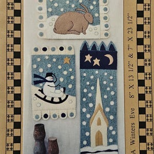 May include: A Winters Eve craft kit featuring three felt designs: a bunny, a snowman on a rocking horse, and a church. The designs are on a light blue background with white polka dots. The dimensions are 8" x 13 1/2" and 7" x 23 1/2".