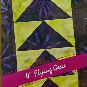 May include: A quilting pattern for making 4-inch flying geese blocks. The pattern features a yellow and black fabric with a purple floral design. The text "smart-ease™ ...creative shortcuts for busy quilters" and "4" Flying Geese" is visible. The text "fast - easy - smart!" is also visible.