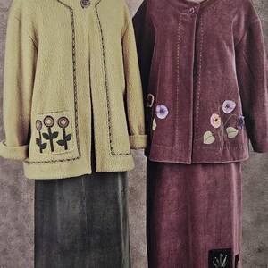May include: Two jackets and skirts are displayed. One is a light olive green fleece jacket with floral embroidery on the pockets, paired with a dark gray skirt. The other is a burgundy velvet jacket and skirt set, also with floral embroidery.