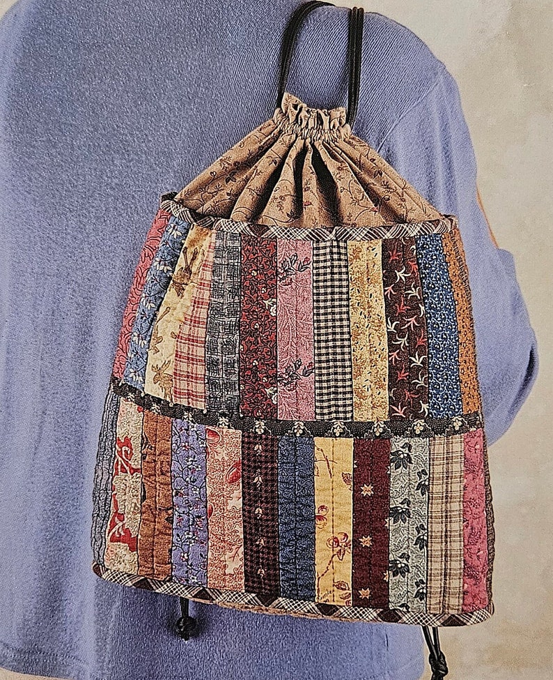 May include: A patchwork drawstring bag with a brown fabric lining and black drawstrings. The bag is made of various colorful fabrics with floral and geometric patterns.