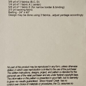 May include: A printed document with text detailing fabric requirements and dimensions for a sewing project. The finished size is approximately 51 cm x 91 cm. The document lists materials, including fabric yardage and batting size.