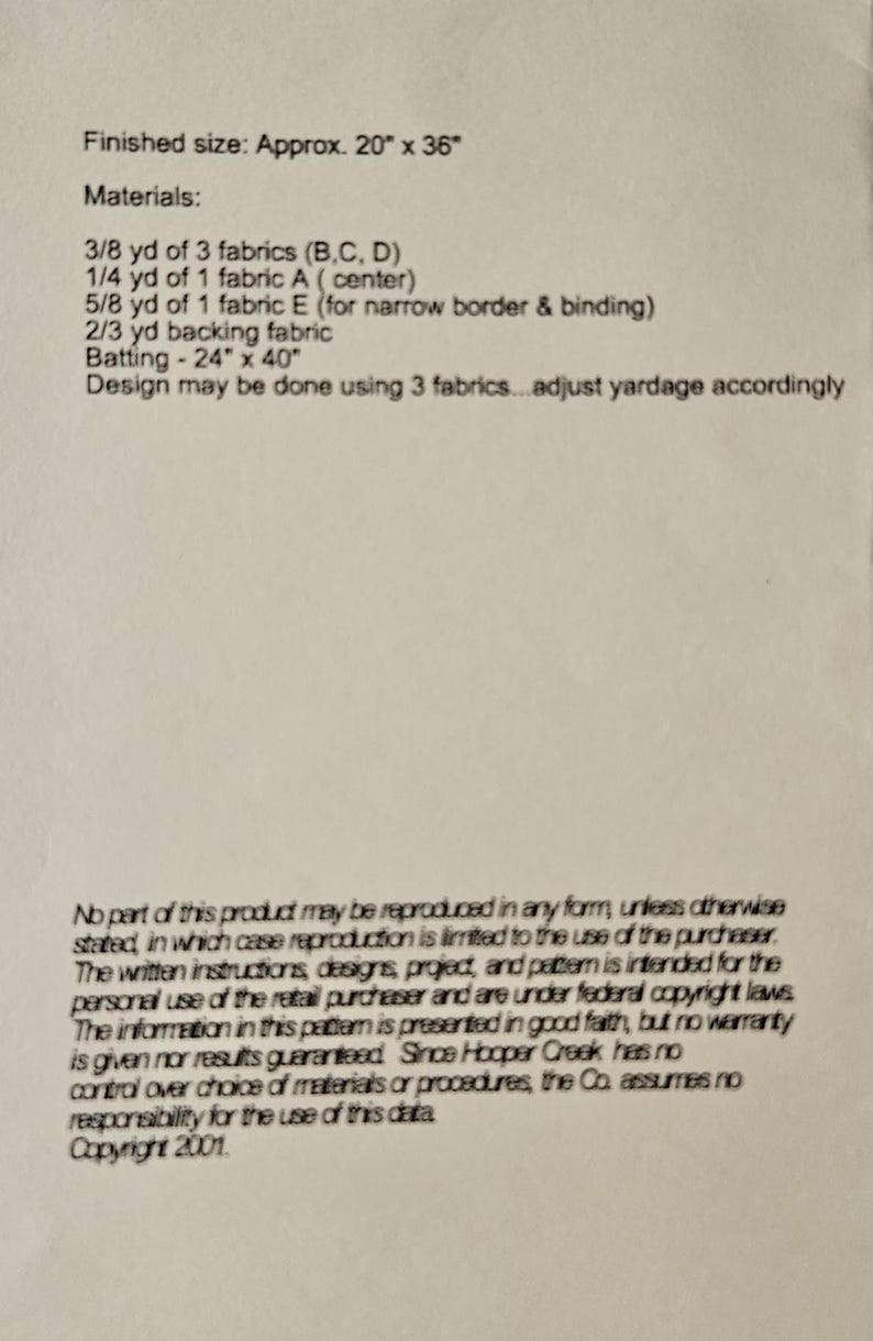 May include: A printed document with text detailing fabric requirements and dimensions for a sewing project. The finished size is approximately 51 cm x 91 cm. The document lists materials, including fabric yardage and batting size.