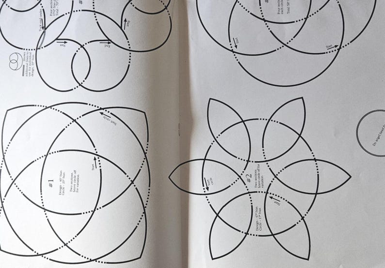 May include: Two open pages of a book featuring black line drawings of geometric patterns. The designs consist of circles, curved lines, and dotted lines, with arrows indicating direction. The designs are labelled with numbers and text.