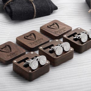 May include: Five wooden boxes with engraved names and dates, each containing a pair of silver cufflinks. The cufflinks are engraved with initials.